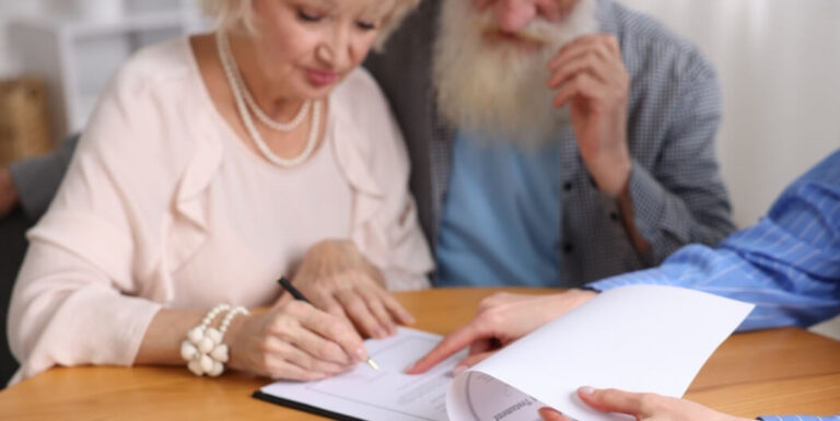 Elderly Couple Signing Assisted Living Facility Residency Agreement Document
